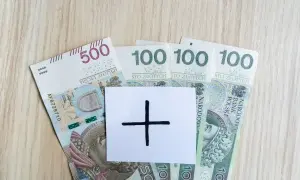 Polskie banknoty 500 i 100 zł. Na białej kartce symbol plusa. Czy to zapowiedź wyższej pensji?