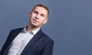 Mężczyzna w garniturze i białej koszuli, patrzący w górę.