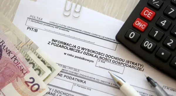 Polskie banknoty, kalkulator i formularz PIT/B. Kto to rezydent podatkowy? To osoba, która rozlicza się z dochodów w Polsce.