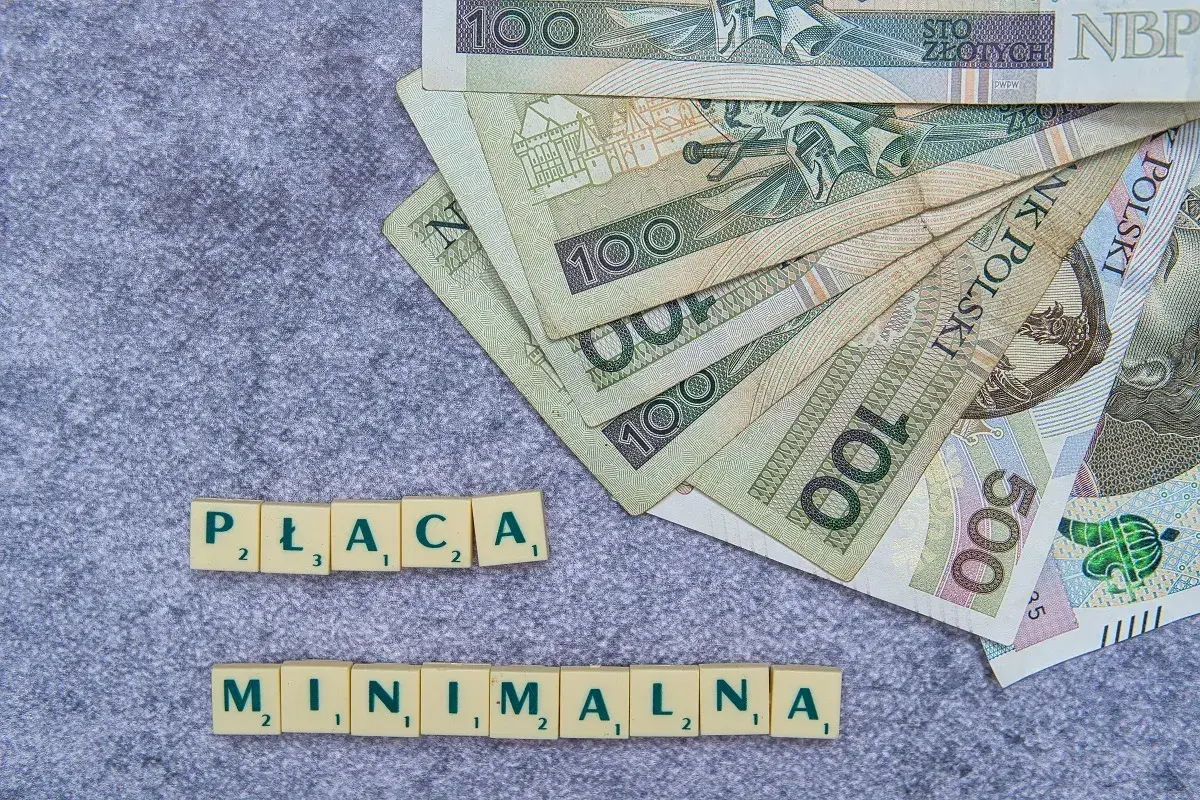 Pieniądze i litery układające się w "PŁACA MINIMALNA". Czy to zapowiedź podwyżki dla pielęgniarek w 2026 roku?