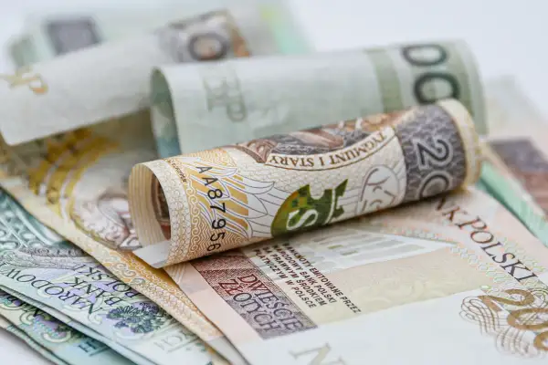 Zwijane polskie banknoty, w tym 200 zł, na białym tle. Może to być wizualizacja do tabeli 13 emerytura 2026.